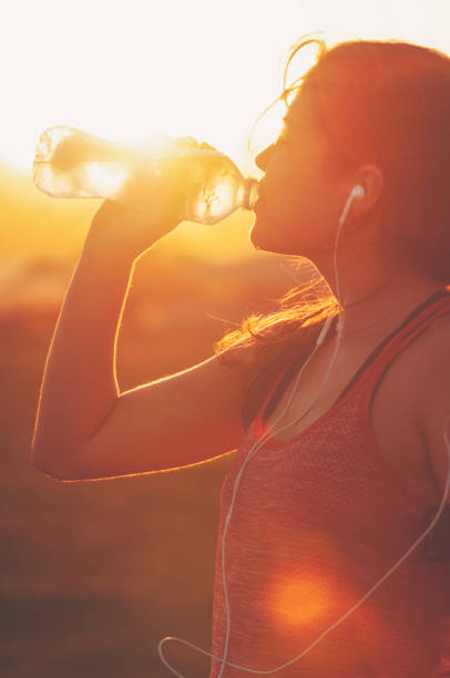 istock Silhouette of a woman drinking form a water bottle. 948266706