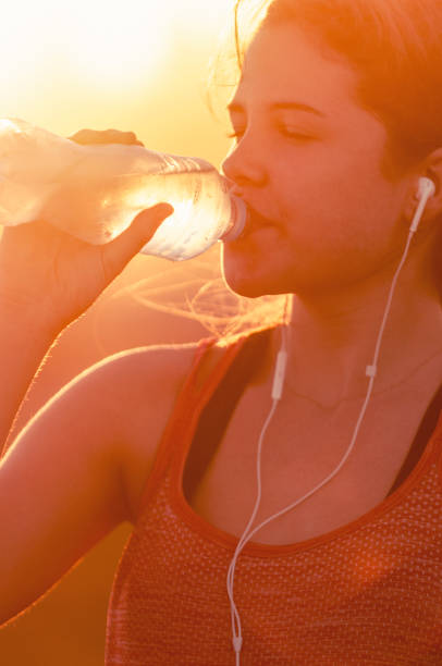 istock Silhouette of a woman drinking form a water bottle. 948268352