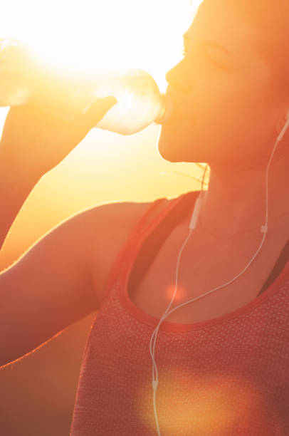 istock Silhouette of a woman drinking form a water bottle. 948268600