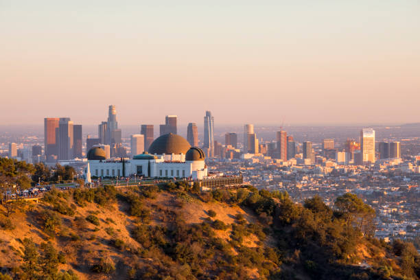 Downtown Los Angeles and Griffith Observatory at Sunset Downtown Los Angeles skyline behind Griffith Observatory at sunset griffith park photos stock pictures, royalty-free photos & images