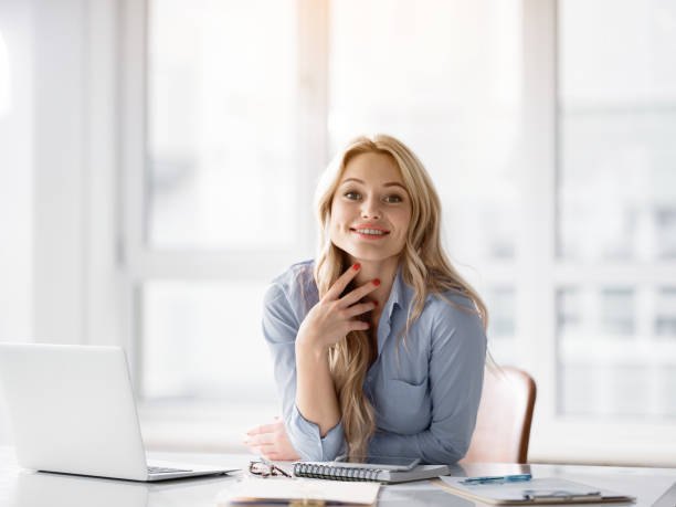 istock Cheerful blond woman working at desktop 948285964