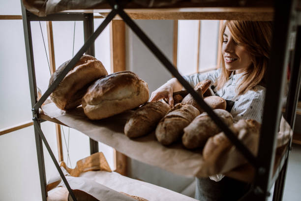 istock Happy Woman Putting Fresh Bread In Paper Bag 948289908