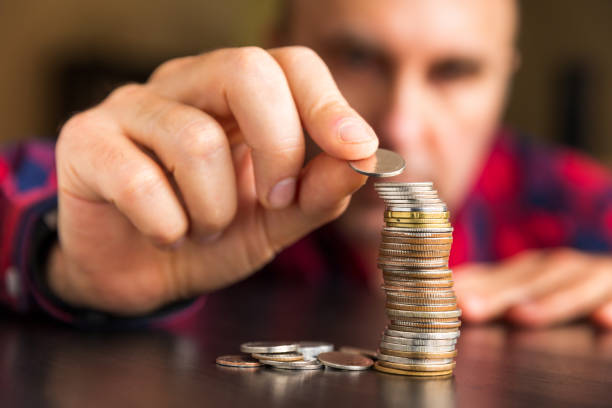 homem conta suas moedas em uma tabela - stack quarter coin us coin - fotografias e filmes do acervo