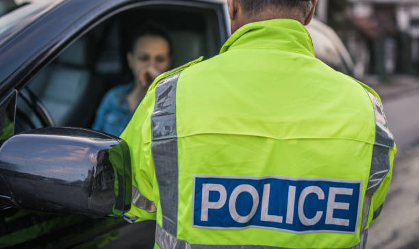 Police man pulled over car Young woman pulled over by police officer on the road. traffic fine stock pictures, royalty-free photos & images