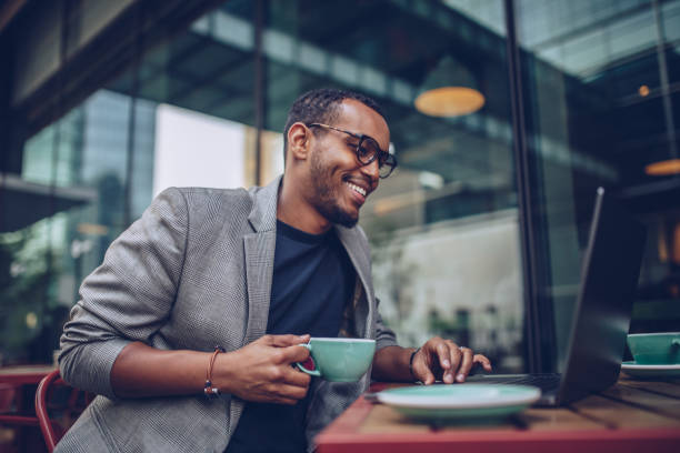 istock Handsome man sitting in coffee shop and using laptop 948317766