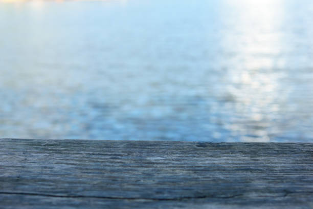 istock empty wooden plate with pond or nature background. 948331434