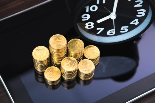 istock Coins stacks and alarm clock with tablet computer and financial graph, business planning vision and finance analysis concept 948333778