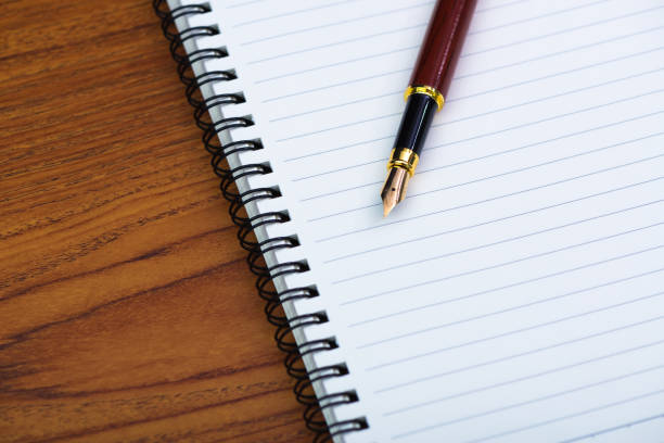 istock Fountain pen or ink pen with notebook paper on wooden working table with copy space, office desk concept. 948333804