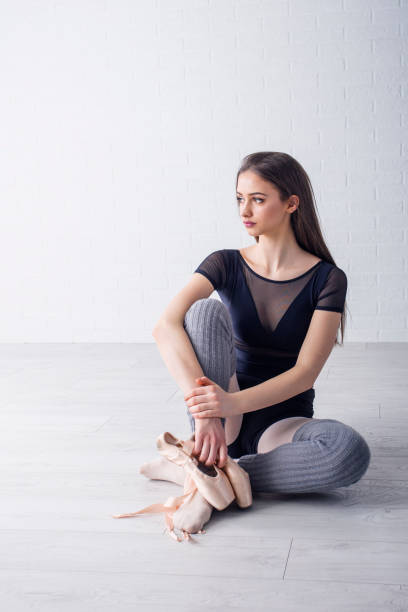 istock Young beautiful ballet dancer stretching on the floor and exercise 948348894