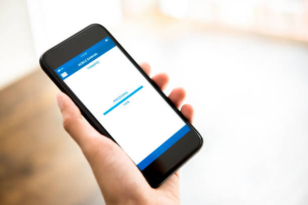 istock Hand holding smartphone showing processing of money transferring online via application 948351342