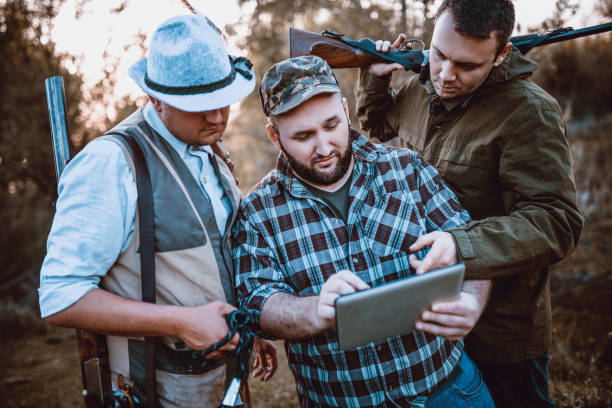 istock Group of Hunters Looking for GPS Coordinates on Tablet in Nature 948352588