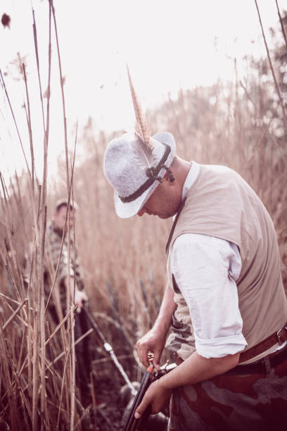 istock Hunter Putting Bullets in his Gun and Preparing for Hunting 948358294