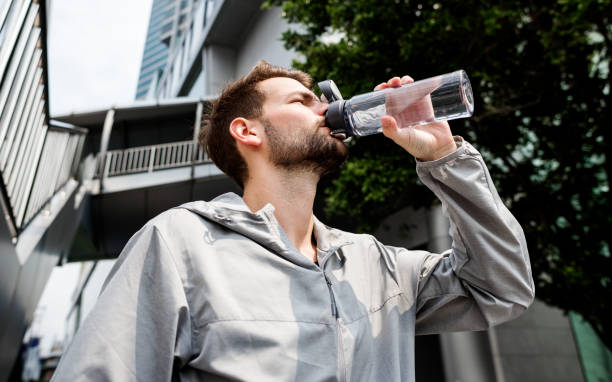 istock Man drinking out of a water bottle 948358556