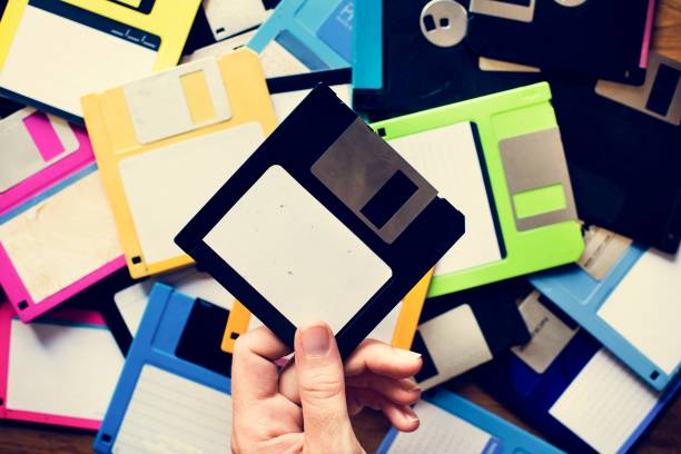 hand mit diskettenlaufwerk datenspeicherung - computerdiskette stock-fotos und bilder