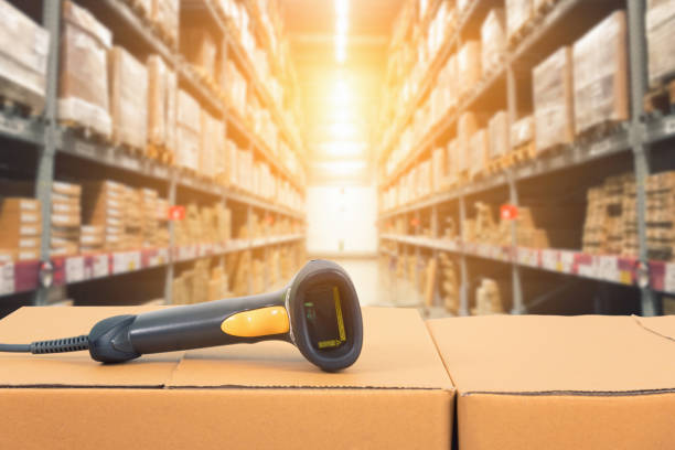 Barcode scanner in front of modern warehouse Barcode scanner in front of modern warehouse and scanning code on cardboard box af_istocker stock pictures, royalty-free photos & images