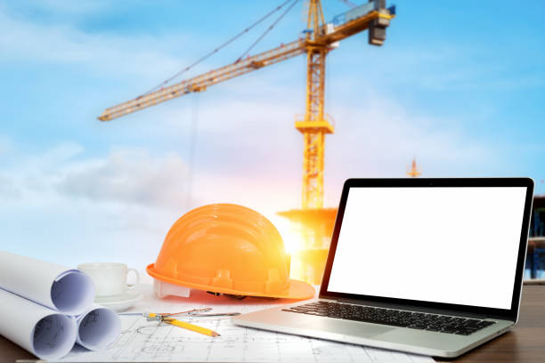 istock safety helmet and Laptop with blank screen on table 948369594
