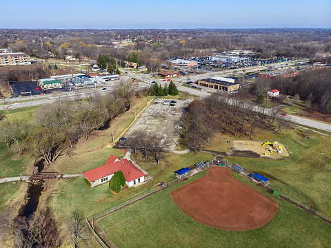 Aerial view of city park. View of the parking, playground, athletic field. Early spring time