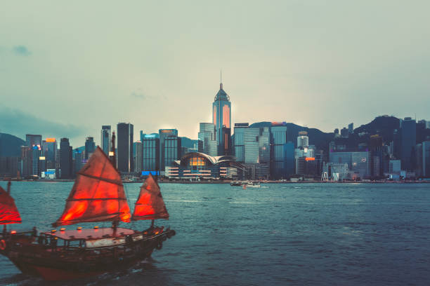 istock Hong Kong Victoria Harbor night view with junk boat on foreground 948384544