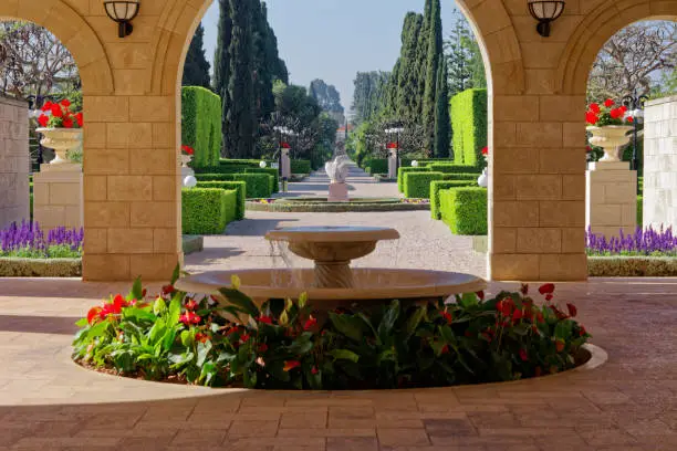 Panoramic view of lush and exquisite Bahai garden with blooming flowers and shaped trees in city of Acco, Israel.