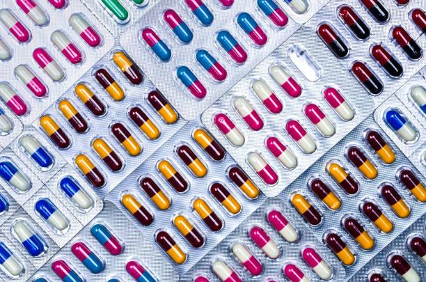 Full frame of colorful antimicrobial capsule pills. Quality control error in pharmaceutical manufacturing. Blister pack missing one capsule of antibiotic pill. Drug resistance. Defective concept. marco completo de colorido píldoras cápsulas antimicrobianas. error de control de calidad en la fabricación de productos farmacéuticos. falta una cápsula de píldora de antibiótica blíster. resistencia a los medicamentos. concepto defectuoso.