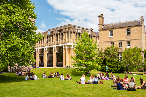 Oxford, England - June 19, 2013: Students relaxing on the grass outside Balliol College of Oxford University