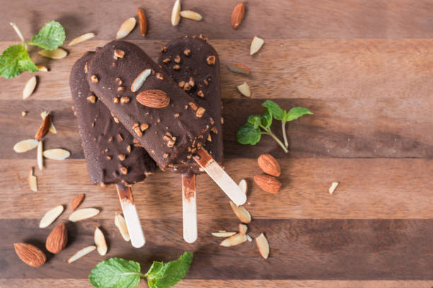 istock Ice cream covered with chocolate and almonds sticks. Top view. 948404494