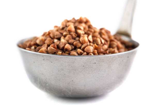 istock buckwheat in metal bucket on white background. Isolate 948411638