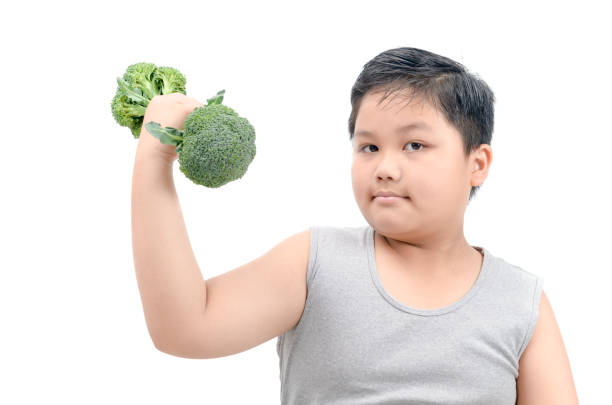 istock Obese fat boy holding a broccoli dumbbell isolated 948411776