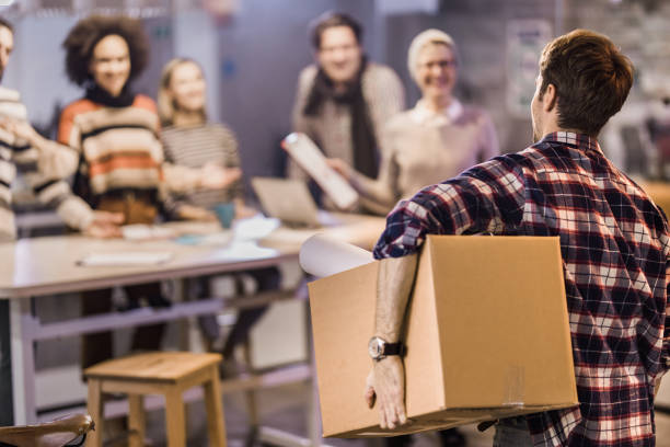 istock Rear view of a freelancer coming back to work while carrying box with his belongings. 948415892