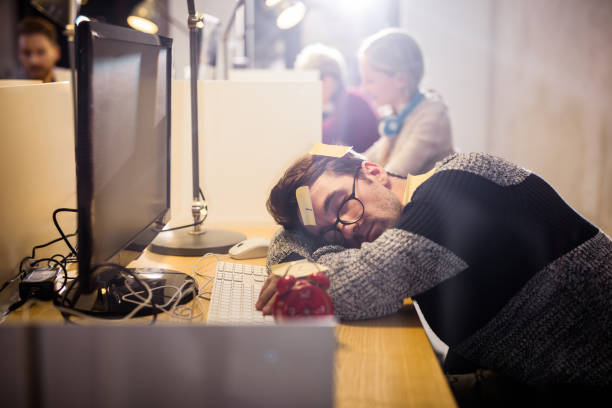 Exhausted freelancer sleeping on the desk in the office.