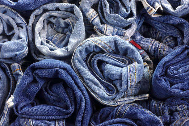 istock Pile of rolled up jeans as background. 948417058
