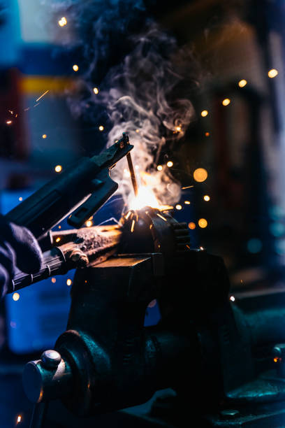 istock Mechanic man welding metal material in garage. 948417626