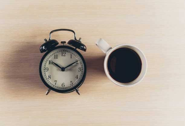istock Coffee with alarm clock on wooden table 948418024