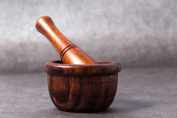 istock Handmade wooden mortar and on gray background. Side view. 948421126