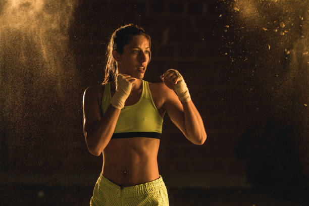 atleta de construir muscular em uma posição de luta em um treinamento de boxe. - sports training muscular build women body care - fotografias e filmes do acervo