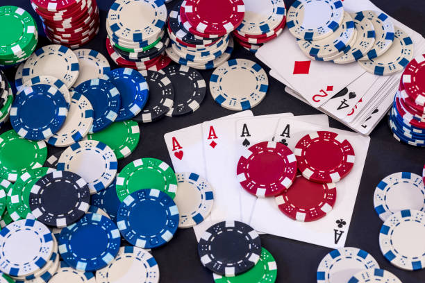 istock Poker chips mixed with cards on the table . 948425752