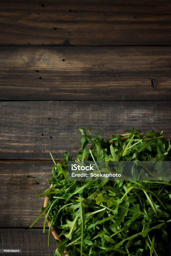 Fresh rucola with water droplets on a dark rustic background Rucola salad on a dark wooden background Annual - Plant Attribute Stock Photo