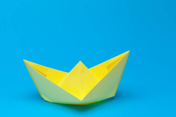 istock Origami paper boat on blue background 948430546