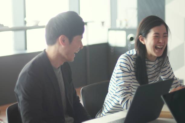 young man and woman working in modern share offices - laptop partnership looking communication imagens e fotografias de stock