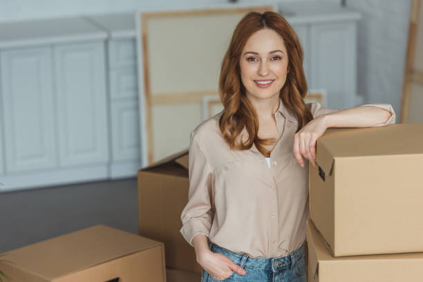 istock attractive smiling woman leaning on cardboard boxes at new apartment, relocation concept 948444664