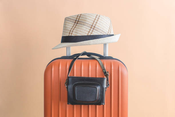istock Luggage with hat and camera studio shoot isolated on beige background. 948445174