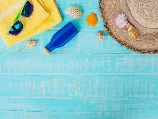 istock Beach accessories including sunscreen, hat beach, shell, yellow towel and retro camera on bright blue pastel wooden background for summer holiday and vacation concept. 948445194