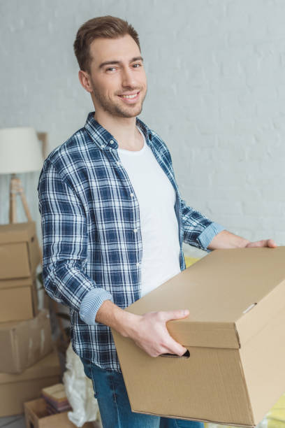 istock smiling man with cardboard box in hands at new home, relocation concept 948448698