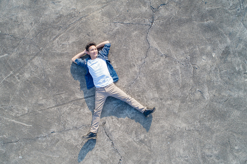 aerial shot of man feel free and lying on the floor