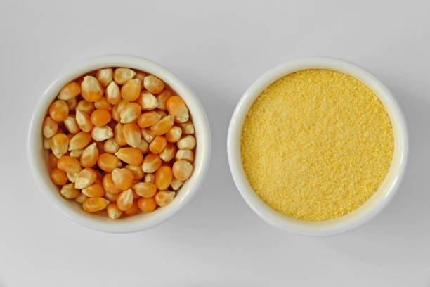 istock Dry corn kernels and corn flour in bowl on white background 948455316