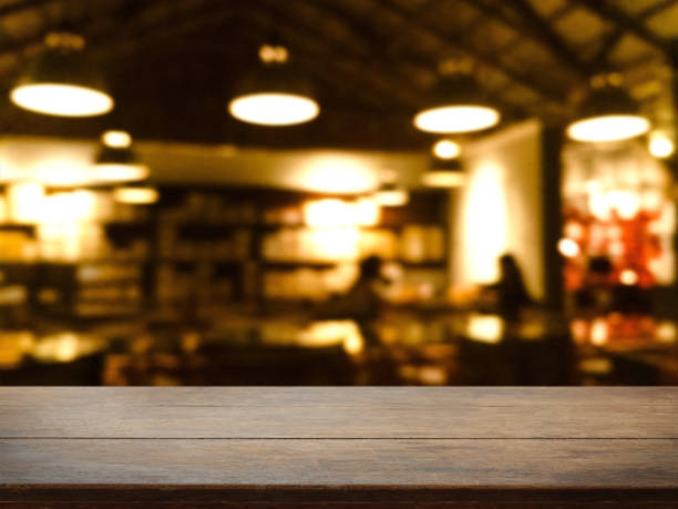 istock Empty wood table top and blurred bokeh cafe and coffee shop interior background with vintage filter - can used for display or montage your products. 948456318