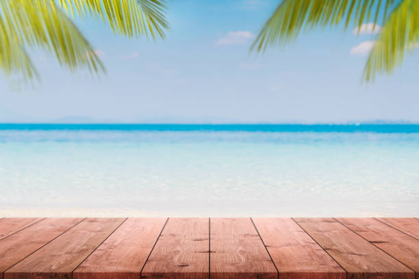 istock Empty wood table top and blurred Palm tree summer beach with blue sea and sky background. - can used for display or montage your products. 948456330