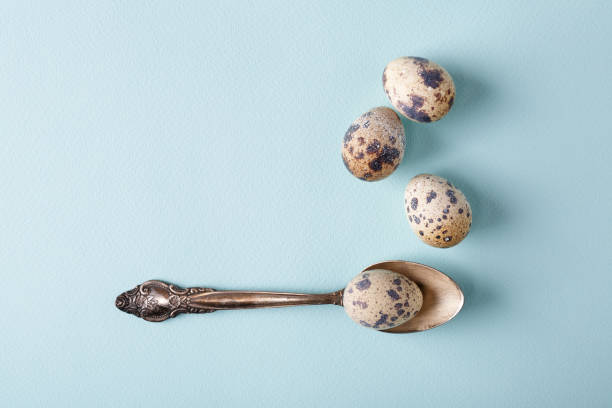 Vintage teaspoon & quail eggs on blue background