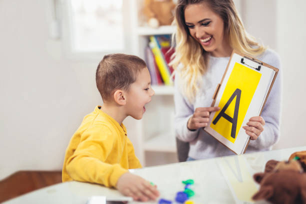 logopädin lehrt die jungen zu sagen, der buchstabe a - child speech therapy adult stock-fotos und bilder