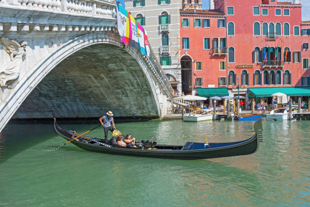 туристы плавают в гондоле на канале в венеции - gondola venice italy canal sailor стоковые фото и изображения